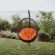 Encase Swing Outdoor Lounge Chair in Poly Rattan with Orange Cushion